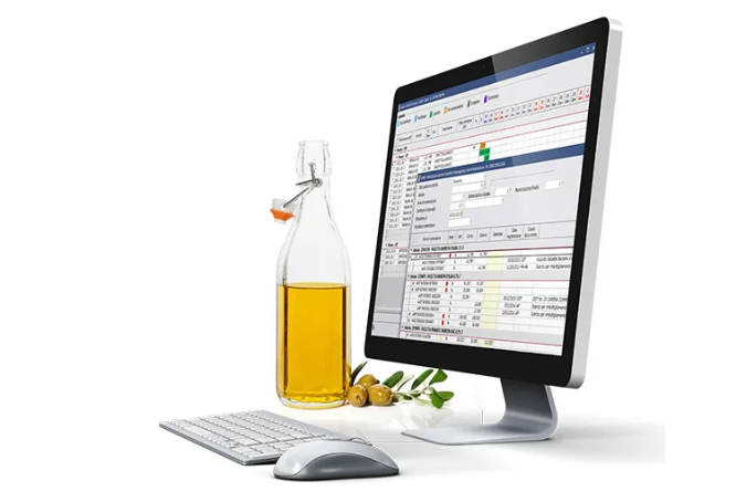 Monitor con software oleario e accanto bottiglia di olio e olive